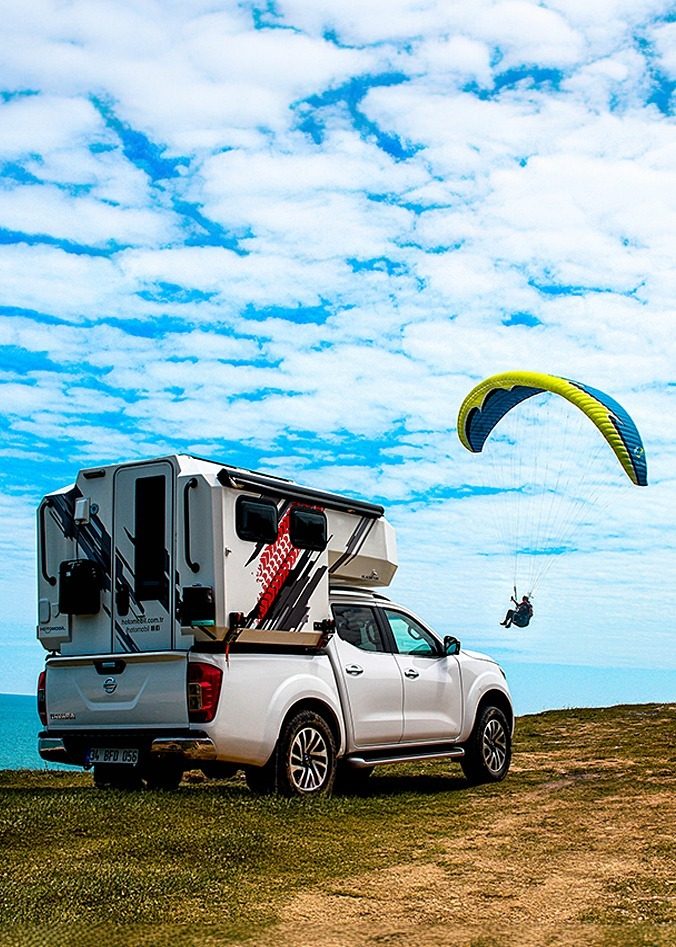 Hotomobil camper by the sea with paraglider in the sky